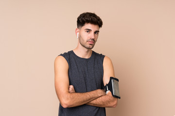 Young sport man over isolated background with arms crossed