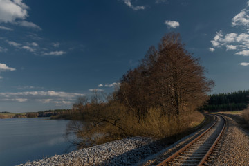 End of Lipno dam with dry grass in dry spring sunny day with railway track