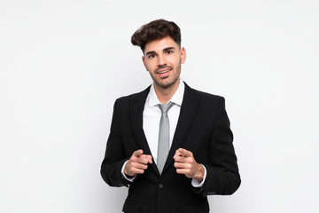 Young businessman over isolated white background points finger at you