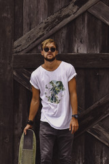 Hipster style guy. young skater man with a skateboard in casual wear