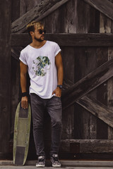 Hipster style guy. young skater man with a skateboard in casual wear