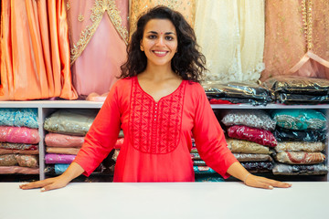 indian seller women in red kurta stand in her studio showroom