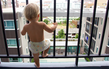 Cute blond caucasian child self isolated staying at home balcony as a prisoner because of...