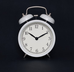 Old-style alarm clock, black and white, it's ten past ten.