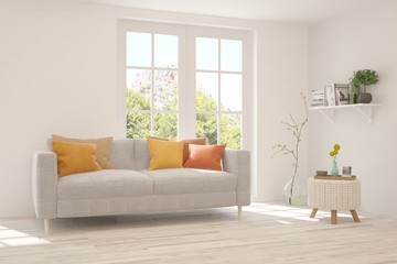 Fototapeta premium White living room with sofa and summer landscape in window. Scandinavian interior design. 3D illustration