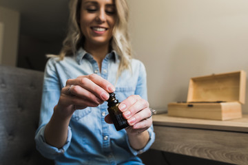 Young woman opening a bottle of essential oil