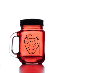 an old jar with a picture of strawberries on it and white background isolated