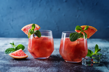 Ruby red grapefruit cocktail with mint leaves in glasses