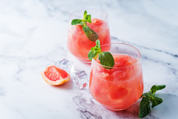 Ruby red grapefruit cocktail with mint leaves in glasses