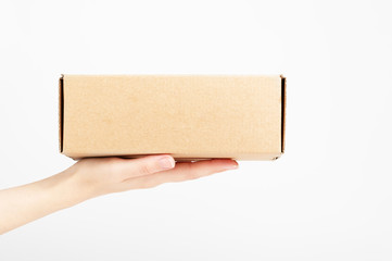 Female hand holding carton box. Food conveyance. Fast delivery service. Mockup style and place for text. Package and shipping concept. Isolated on white