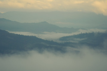 View landscape with silhouettes of mountains range with mist or covered by heavy fog