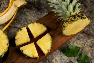 Pineapple slice cut into four pieces on a wooden board