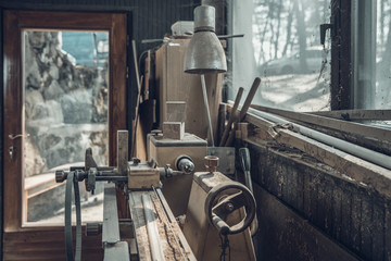 old lathe in an old carpenter's standing by a window covered with dust and spiderwebs