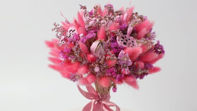 Designer bouquet of dried flowers rotates on a white background, close-up