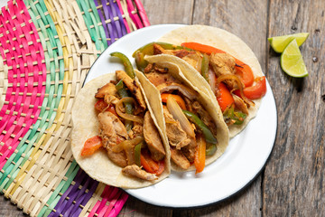 Mexican chicken fajitas tacos on wooden background