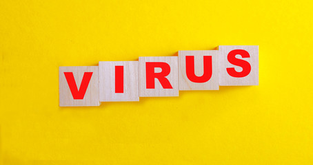 The word virus consists of wooden blocks on a yellow background
