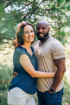 Portrait of happy mixed race couple smiling outside in nature