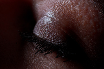 Macro of closed sexy woman eye in a moody environment.