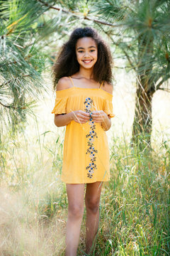 Portrait of smiling curly haired girl outside in nature