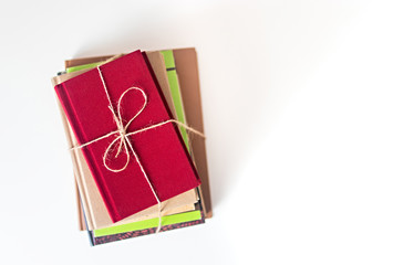 Stack of old books tied with string on a white background with copy space