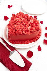
vanilla heart cake with roses on white background