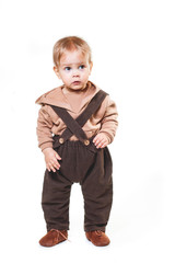 portrait of a charming one-year-old little boy on a white background, dressed in brown trousers, a beige hoodie,