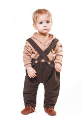 portrait of a charming one-year-old little boy on a white background, dressed in brown trousers, a beige hoodie,