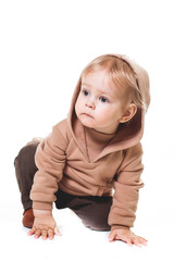 portrait of a charming one-year-old little boy on a white background, dressed in brown trousers, a beige hoodie,