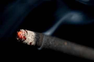 Incense stick, flame and smoke closeup view