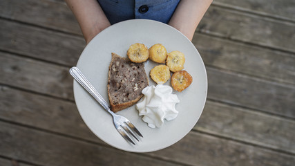Vegan dessert of banana bread with fried bananas and whipped cream
