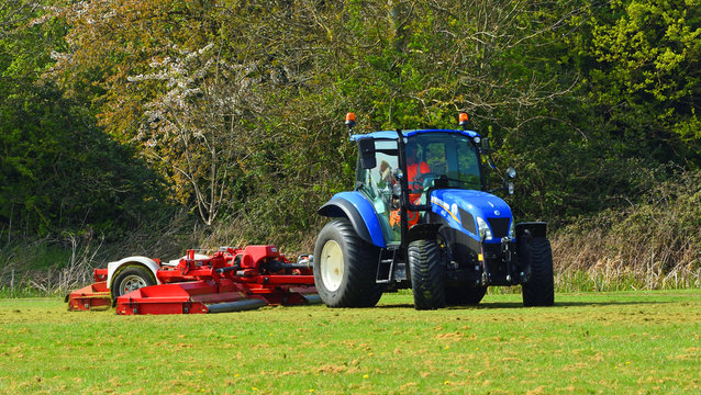  Tractor being used for grass cutting in the park.