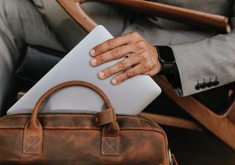 Businessman putting laptop on his bag