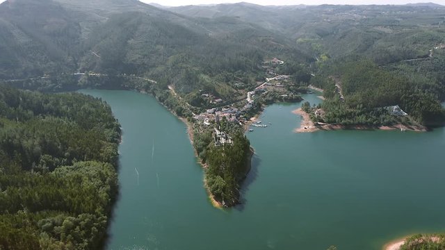 Aerial view of the mountain village of Dornes in Portugal. Scenic view from above on the peninsula and lake or river in the mountains.