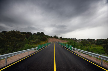 Wet asphalt road and rainy clouds in Spain
