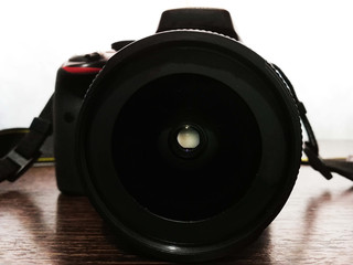 Fotografía tomada a una Cámara Fotográfica mostrando primero el Lente colocado sobre una mesa