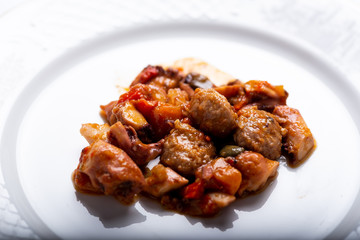 albóndigas con pulpo y patatas en salsa servidas en un plato blanco