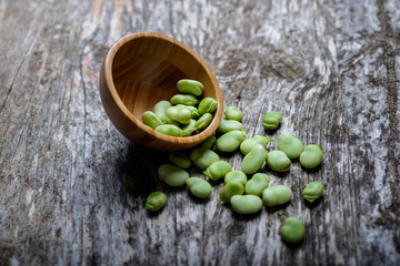 habas en un cuenco de madera sobre un fondo rústico
