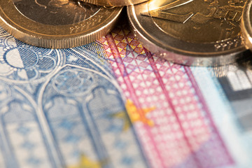 20 Euro bill closeup and Euro coins on top. European monetary union currency. Shallow depth of fiel and coins in focus on top