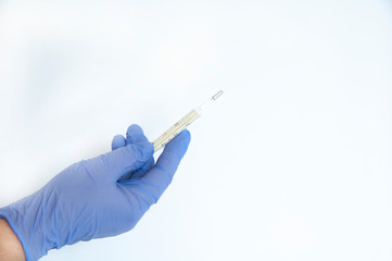 hand in a blue glove with a thermometer. a gloved hand on a white background.