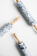 Rolling pin for dough made of gray marble with wooden handles and cradle. On a white isolated background.