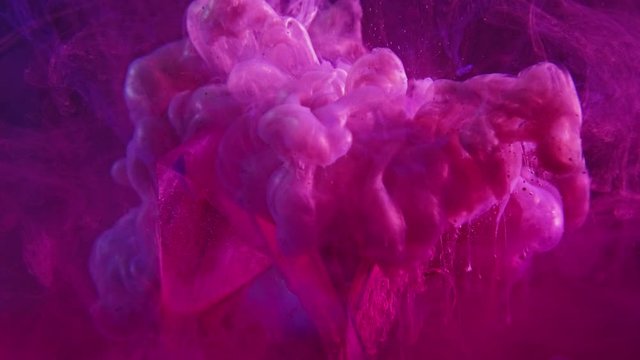 Color fluid splash. Mystical explosion. Fruit dove pink smoke cloud over glass cube in water.