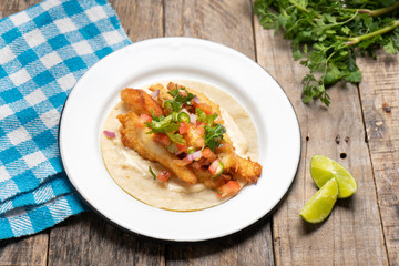 Mexican breaded fish tacos also called ensenada on wooden background