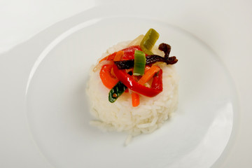white rice with vegetables on a white plate as a side dish