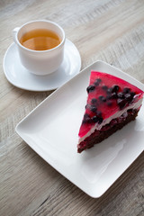 a piece of fruit cheesecake and a cup of tea