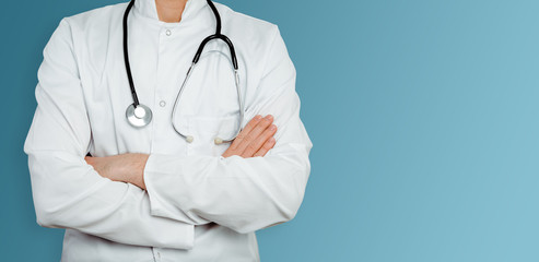 Doctor in a white coat on a blue background. Medical and pharmaceutical concept. Medical service in the fight against diseases and the threat of an epidemic, pandemic. Doctor with a stethoscope.