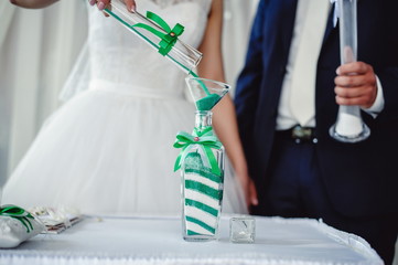 Wedding ceremony, mixing sands is a new family. Close up. The bride, the bride performs the unity...