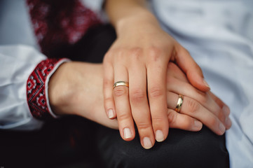Married couple, husband and wife hold each other by the hand, close-up. Gold wedding rings on the fingers of a man and a woman. The hand of a woman is on her husband's hand. Family concept, support.