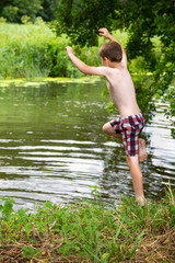 boy jumpin ginto a river