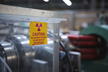 Caution Radioactive Warning During Scientific Experiment High Energy Magnet in Background