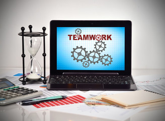 Teamwork with cogs on screen notebook.